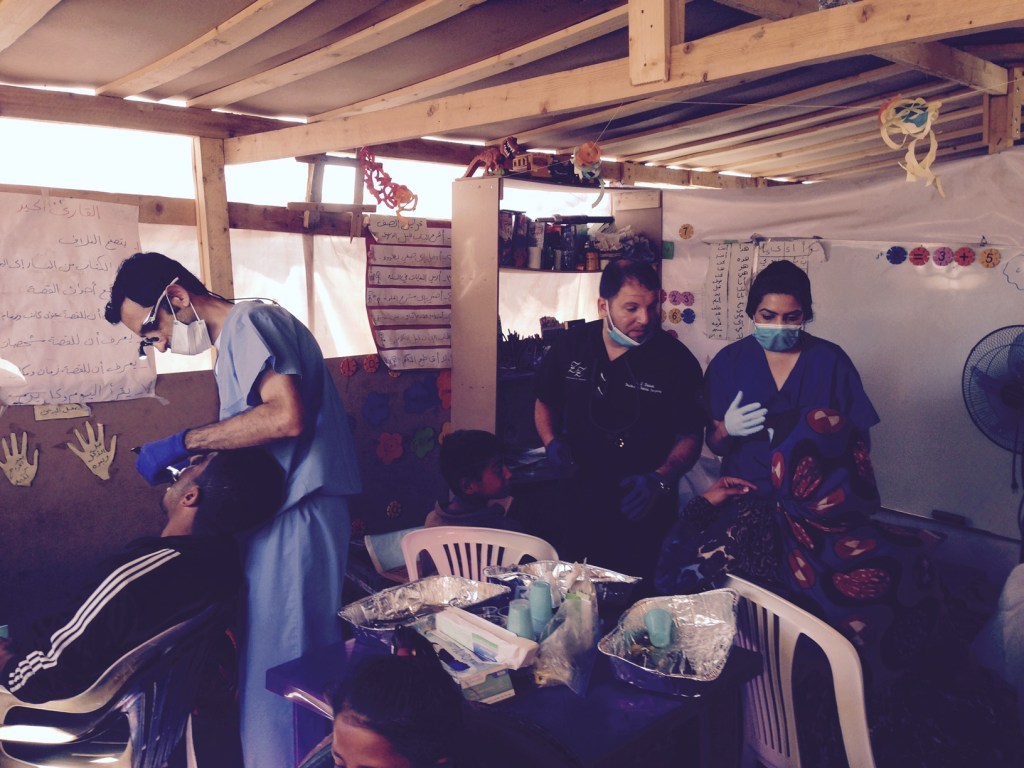 Dr working on a patient with the staff in background 