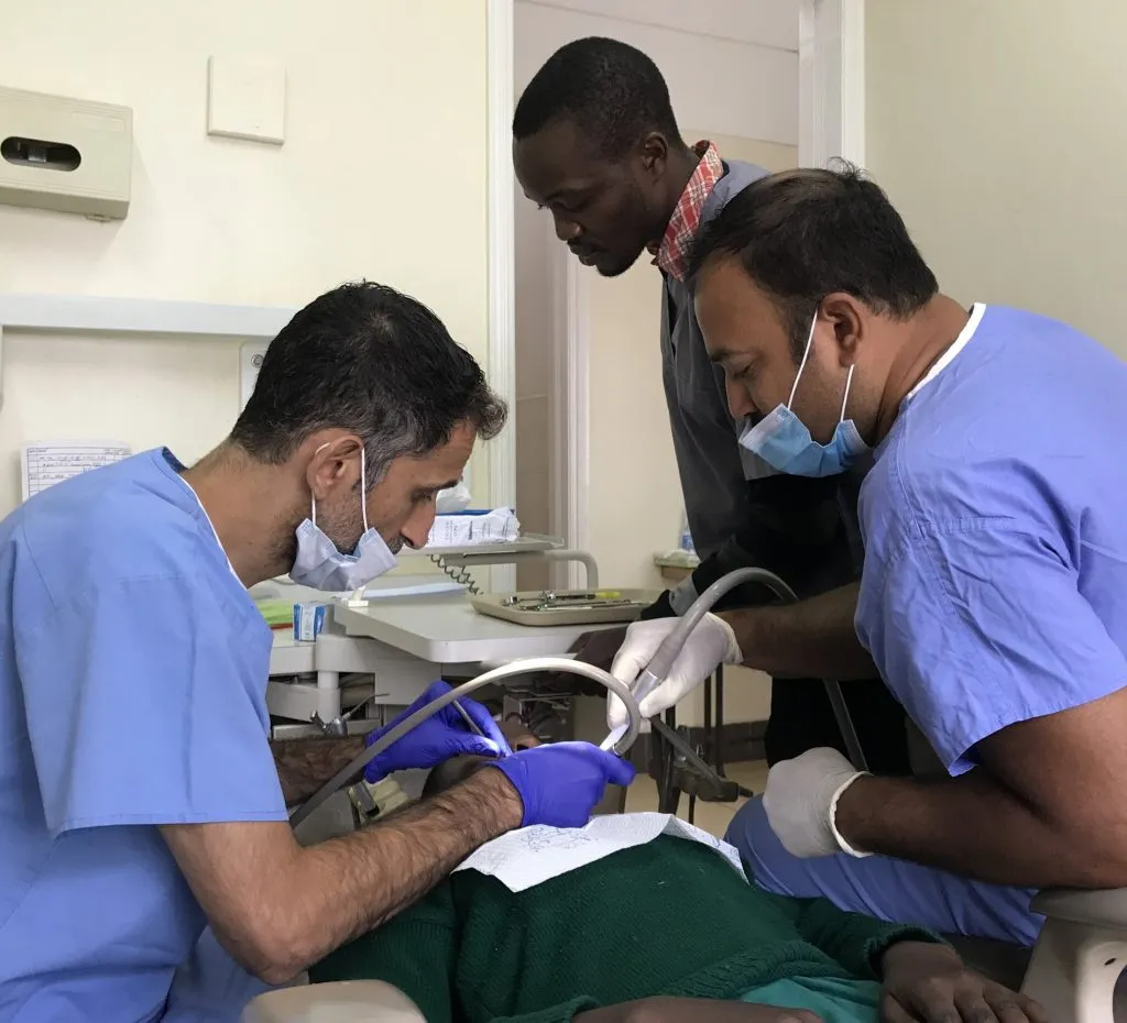 Dr. Sinha with 2 other attendants during a dental procedure