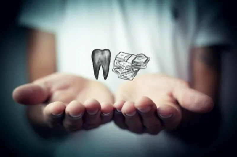 woman holding cash and tooth
